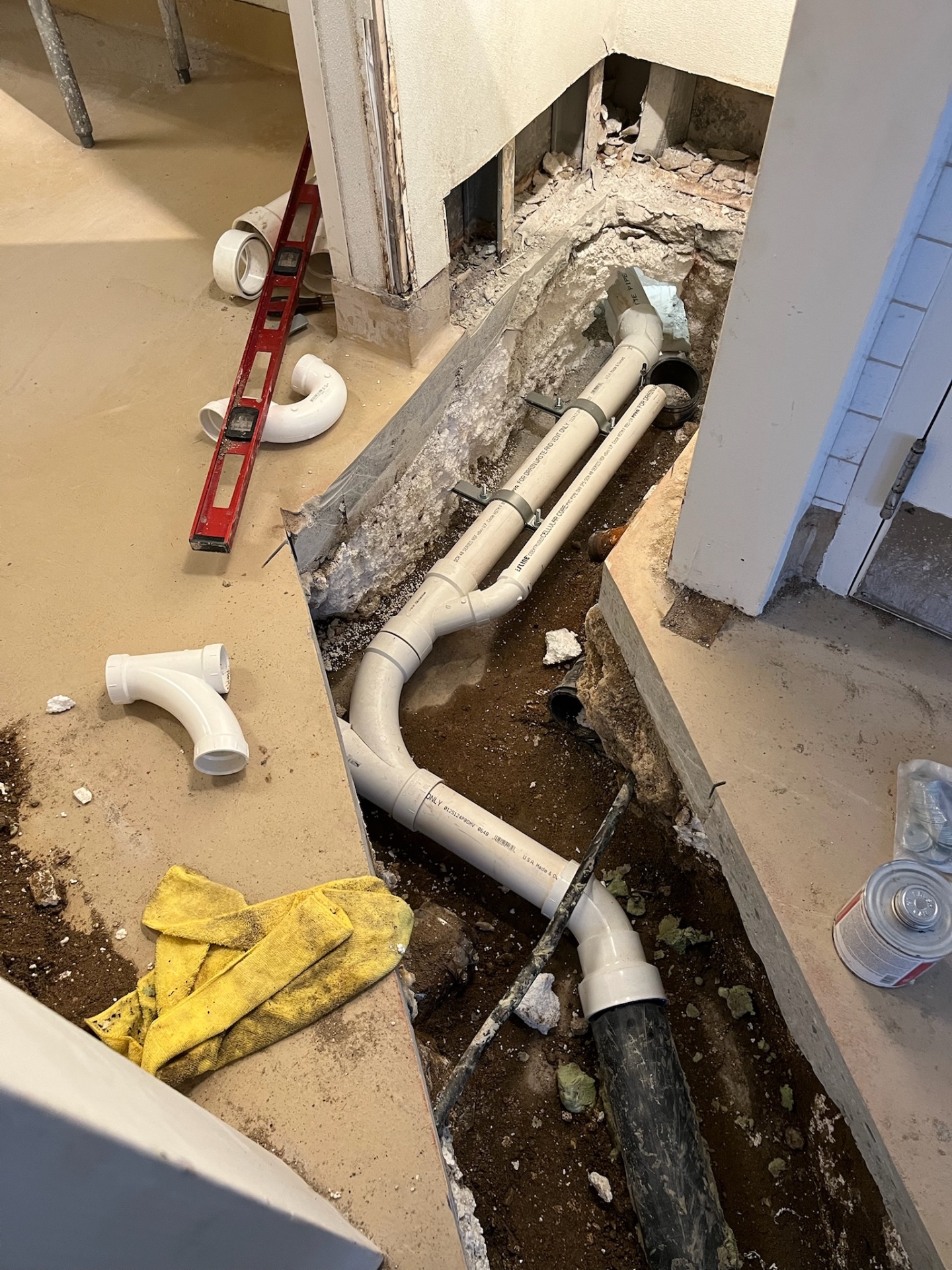 Open trench with PVC drain runs for a repipe