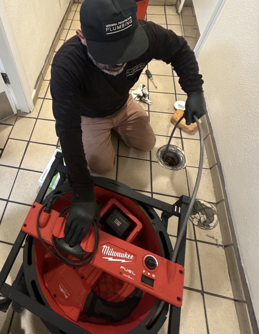 MPP technician using a Milwaukee drain machine to clear a floor drain